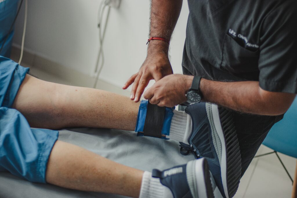 healthcare professional attaching an ankle weight to a prone client
